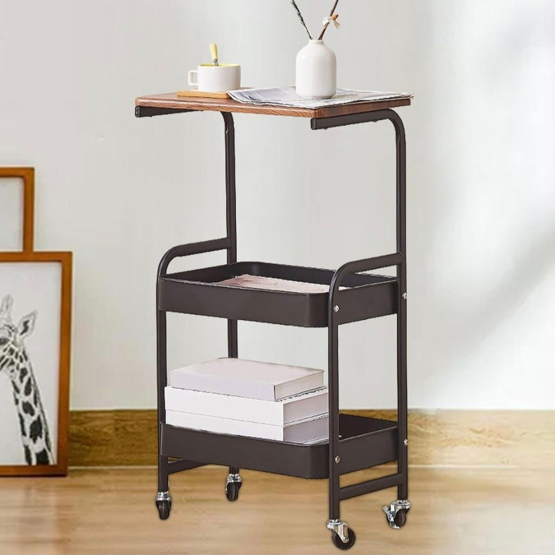 Two-tiered metal serving cart with wooden top in a room setting.