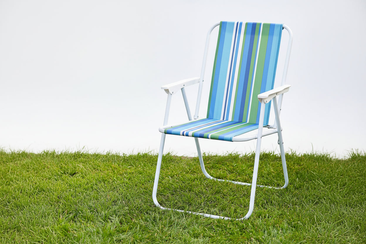 Striped chair on grass with a small table and flowers