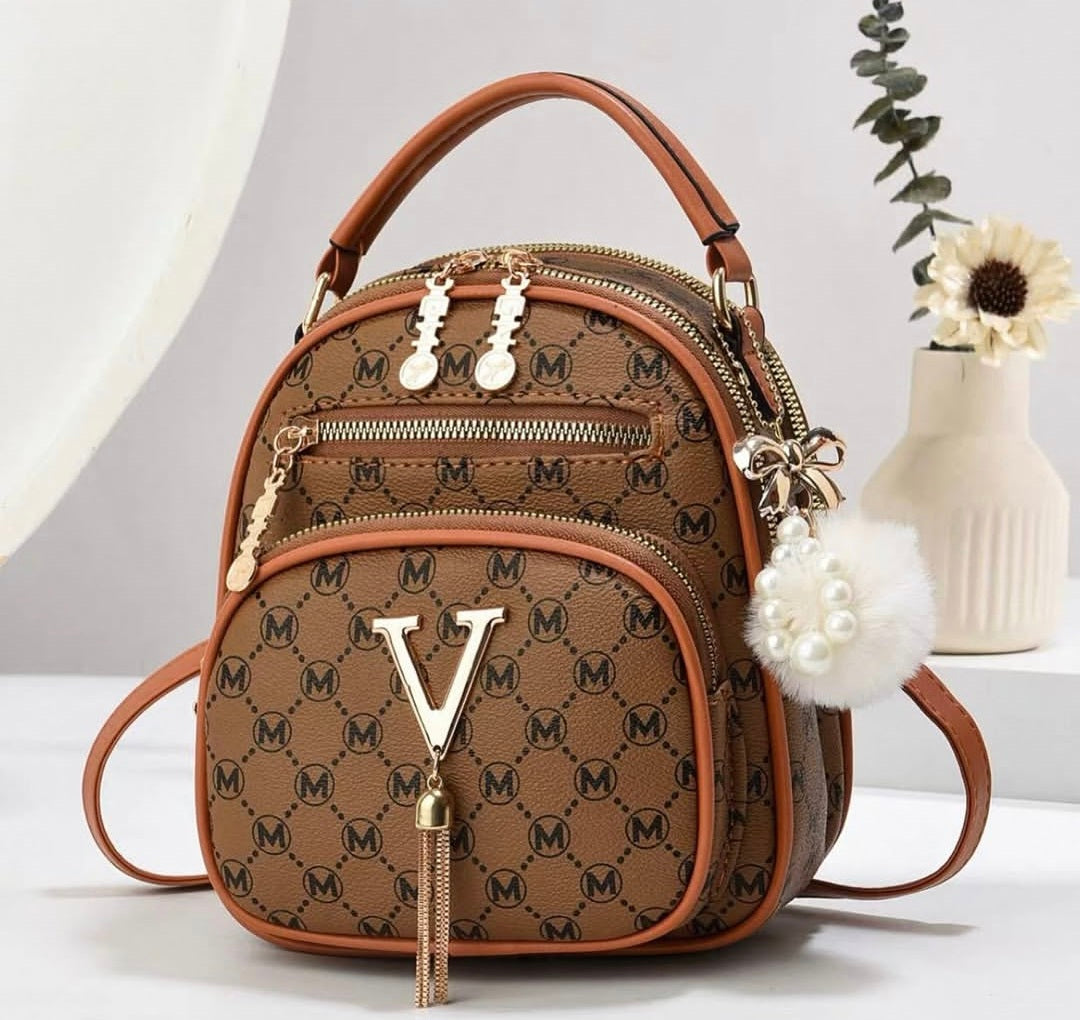 Brown patterned handbag with gold accents on a white surface