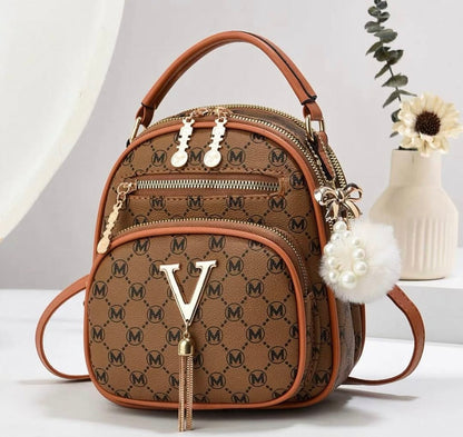 Brown patterned handbag with gold accents on a white surface