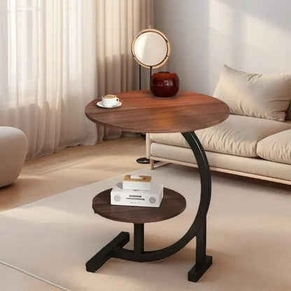 Wooden side table with a lamp and books in a living room setting