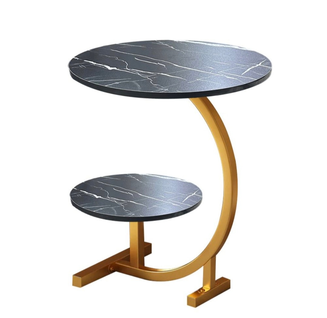 Round side table with marble top and gold curved base on a white background