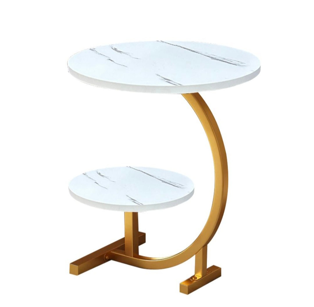 Side table with marble top and gold curved base on a white background