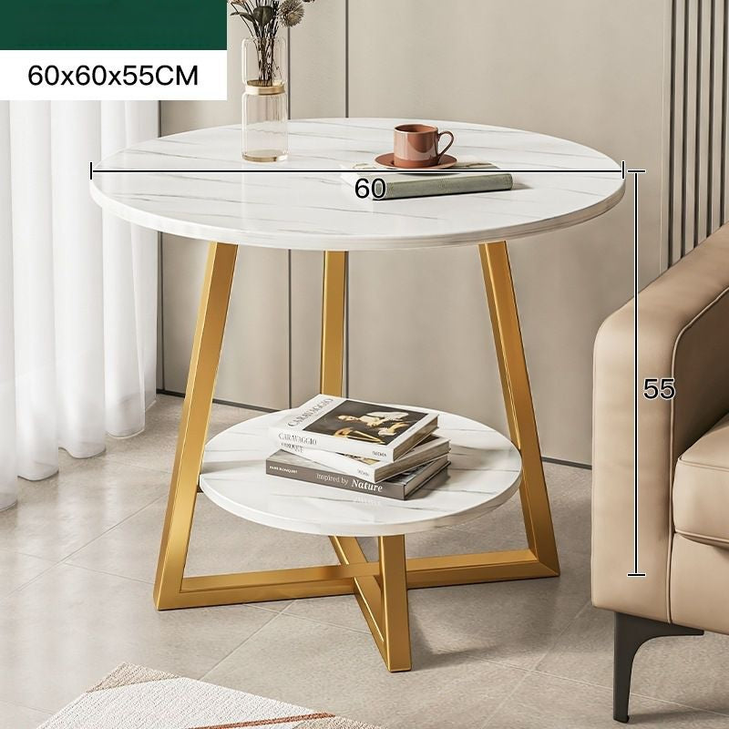 Round side table with gold legs and white marble top in a living room setting