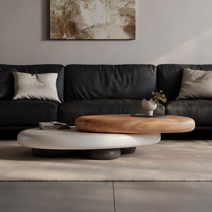 Modern living room with a black sofa, wooden coffee table, and abstract painting on the wall.