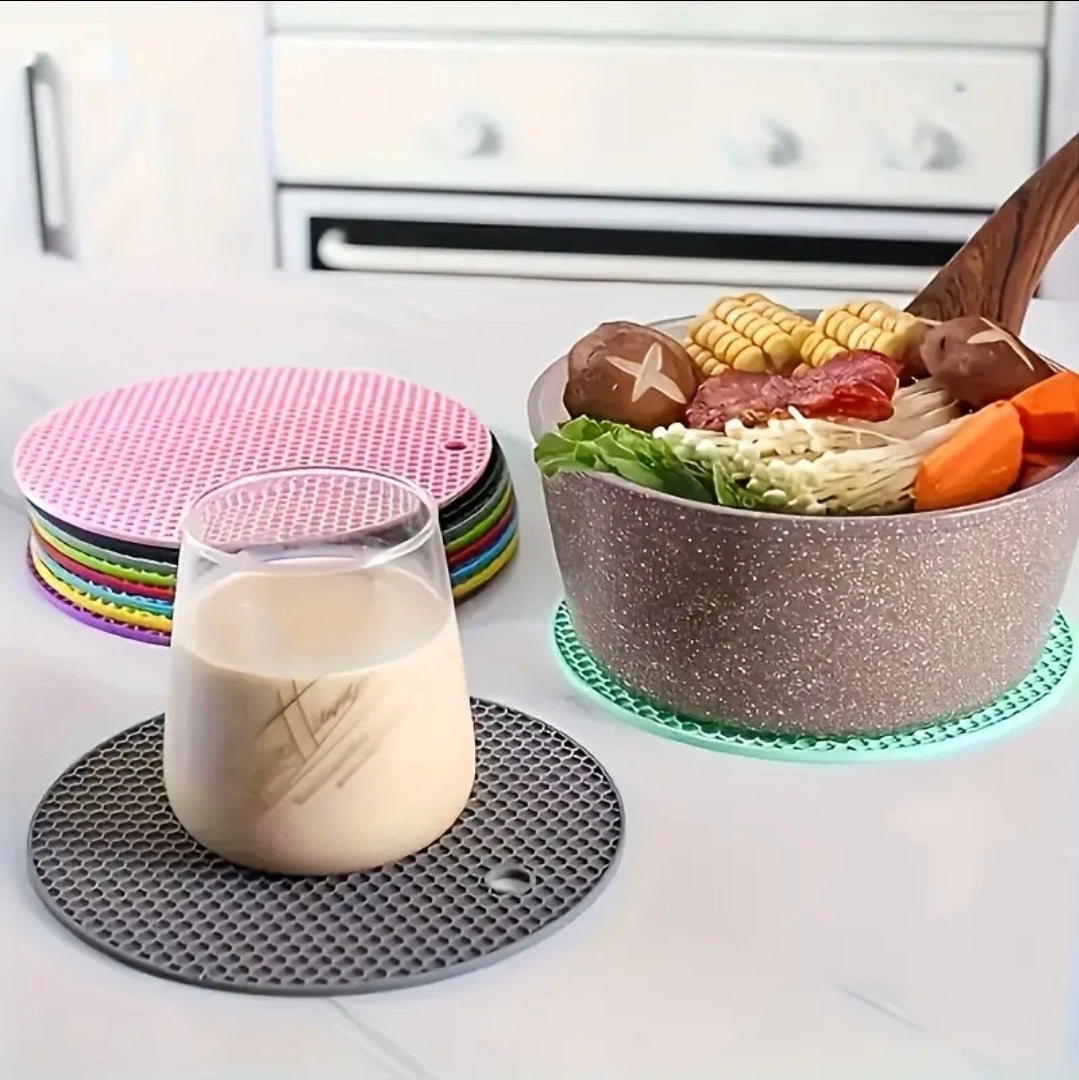 Colorful coasters on a kitchen counter with a glass of milk and a bowl of food.