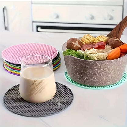 Colorful coasters on a kitchen counter with a glass of milk and a bowl of food.