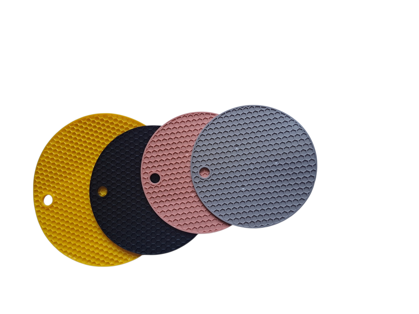 Set of four round silicone coasters in yellow, black, pink, and gray on a white background.