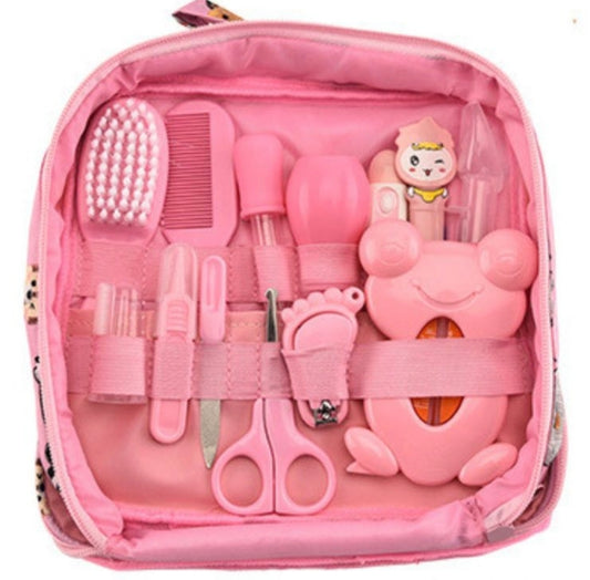 Pink baby nail care and grooming kit organized inside a zippered pink pouch, including a foot file, nail clipper, scissors, comb, brush, and small accessories.