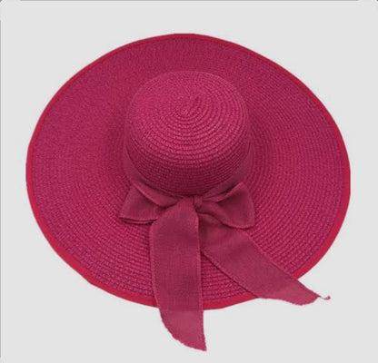 Red straw hat with a bow on a white background