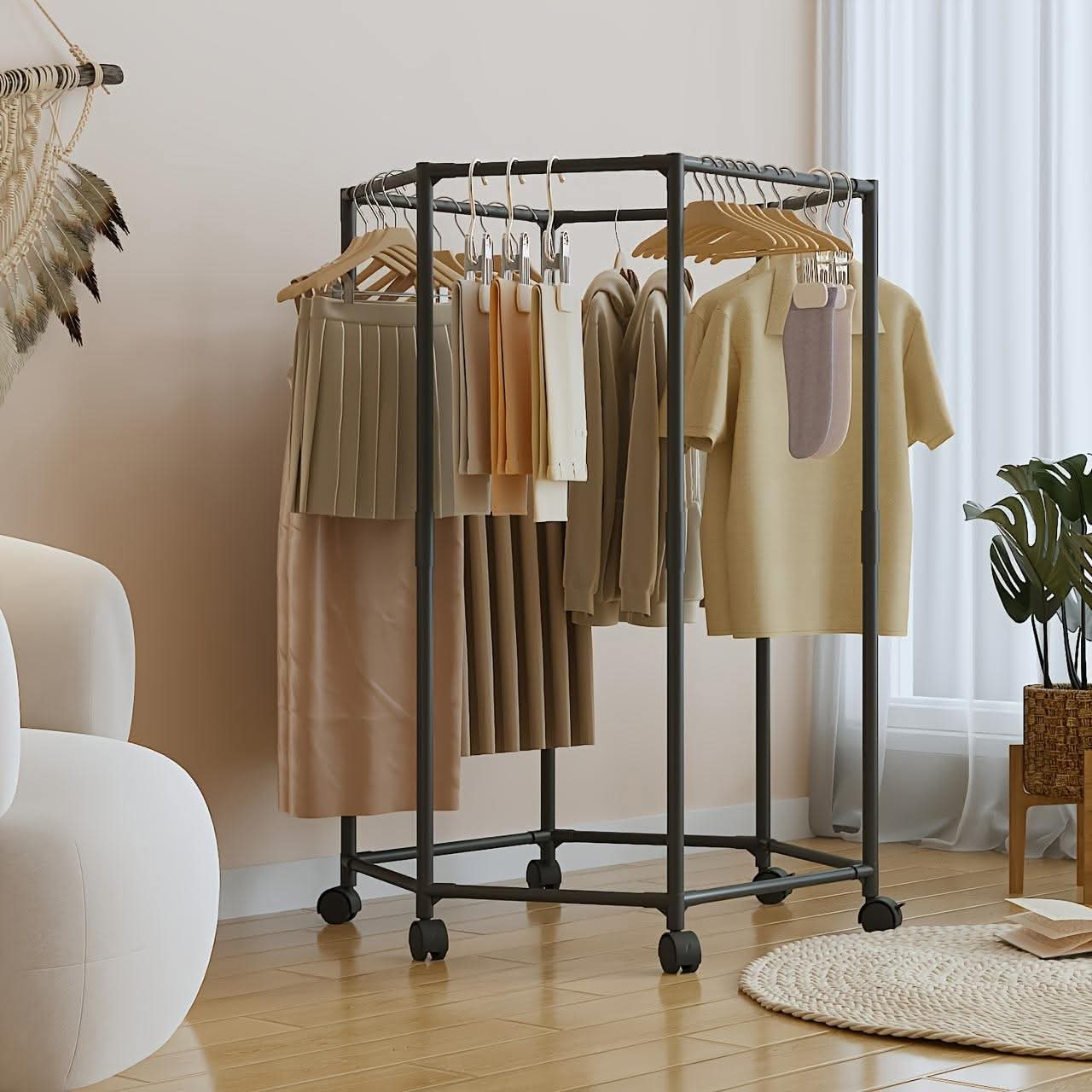 Clothing rack with clothes in a room with a white armchair and plant.