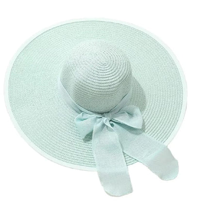 Teal straw hat with a ribbon on a white background