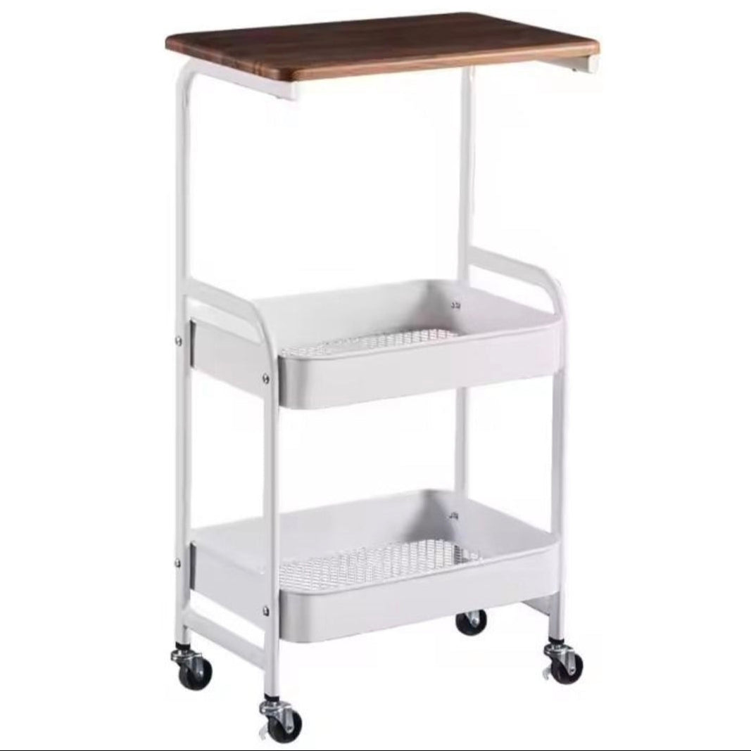 A three-tier rolling utility cart with a white metal frame, black caster wheels, a brown wooden top shelf, and two white wire storage shelves below, shown on a plain white background.