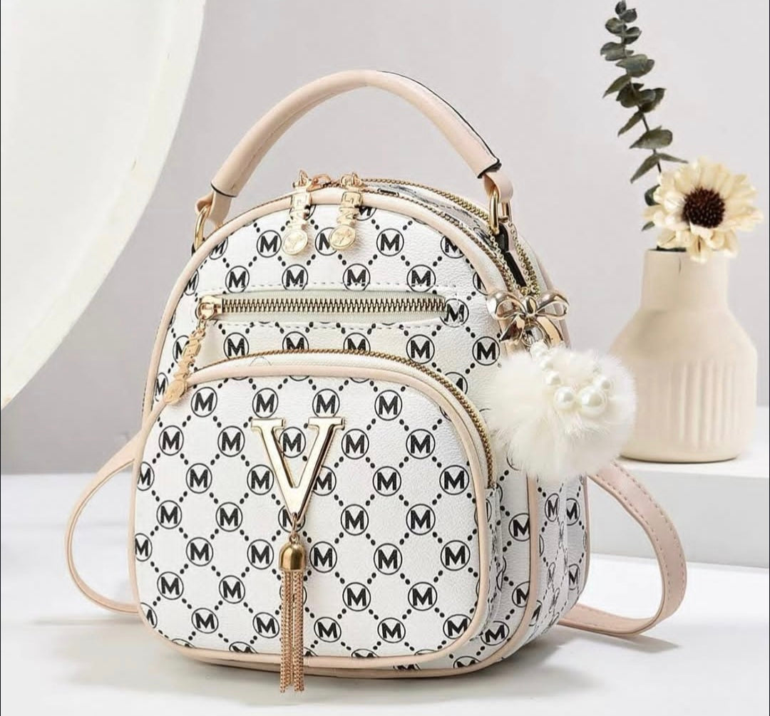 White backpack with black pattern and gold accents on a light background