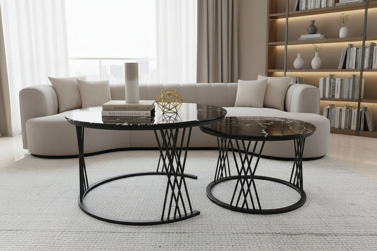 Two black marble side tables with decorative items on a tiled floor.