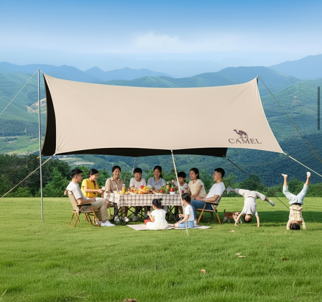 Family enjoying a picnic under a Camel branded canopy in a scenic outdoor setting.