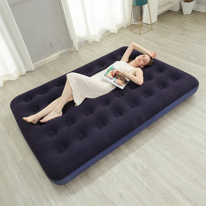 Woman lying on an inflatable mattress in a room with curtains and a table.