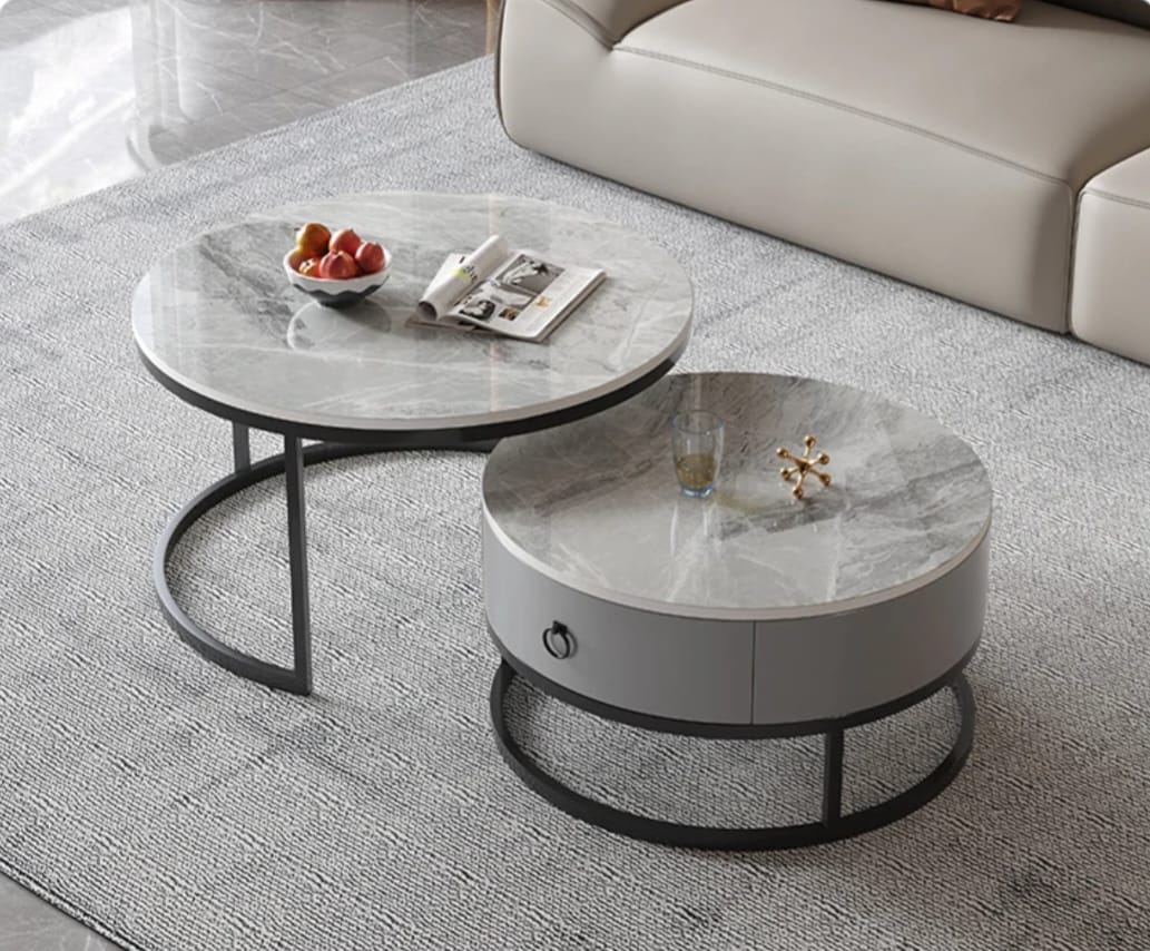 Round marble coffee table with a smaller round table on top, placed in a living room.
