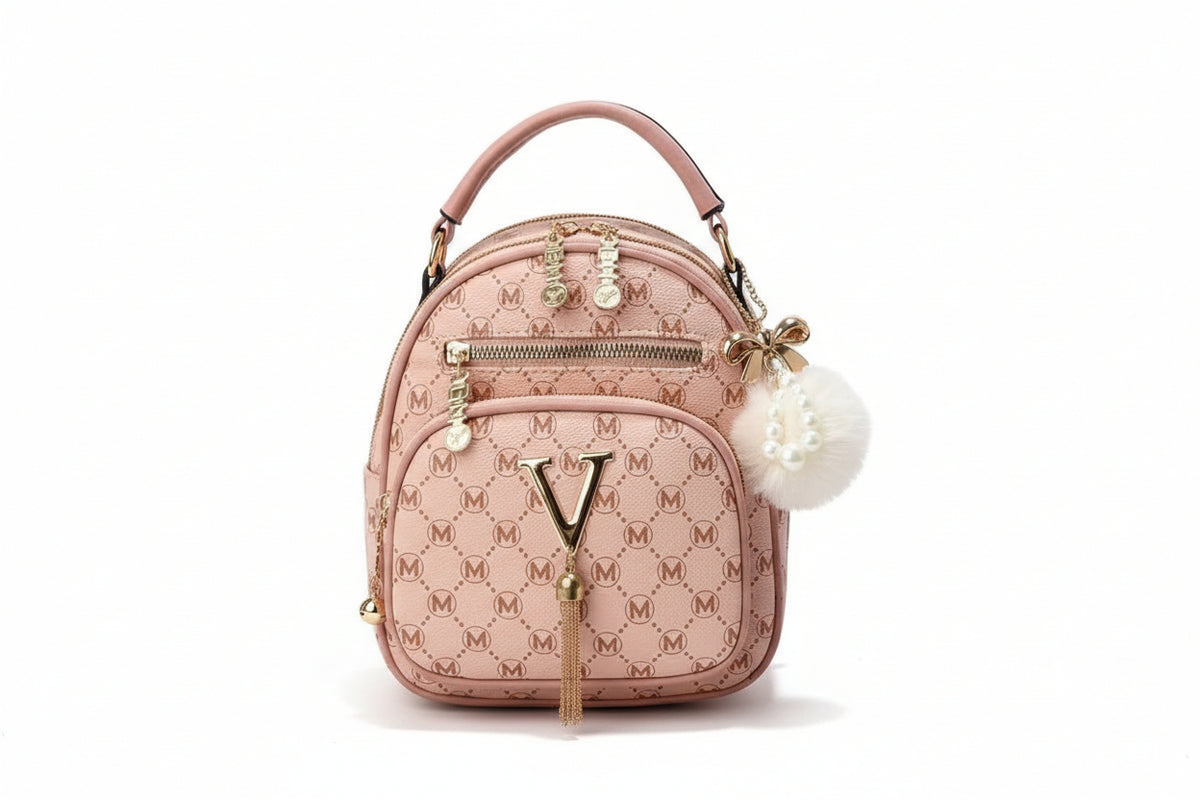 Pink handbag with monogram design on a wooden surface with flowers and fruits in the background