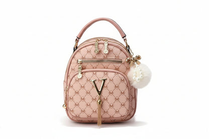 Pink handbag with monogram design on a wooden surface with flowers and fruits in the background