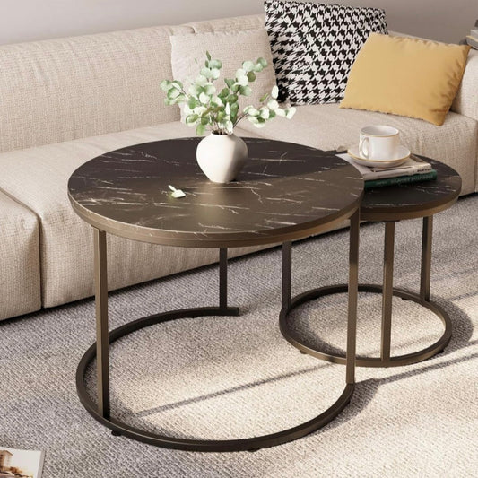 Round marble coffee table with a vase of flowers and a cup on a living room setting.